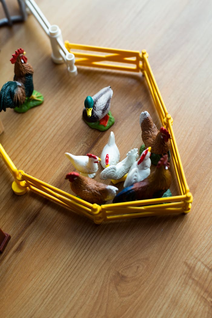 A close-up of plastic toy farm animals in a yellow playset. Perfect for kids' imaginary play.